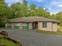 View of home exterior with a gravel driveway, partial shingle and partial stucco at 121 Pheasant Ct, Pittsboro, NC 27312