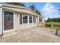 Home exterior showcasing tan siding, a concrete patio, and a decorative front door at 1392 L Cooper Rd, Cameron, NC 28326