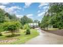 Beautifully landscaped front yard with mature trees and long driveway leading up to the house at 1408 Old Ivey Rd, Apex, NC 27523