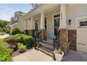 Inviting front porch with stone accents and manicured landscaping at 1458 Wragby Ln, Apex, NC 27502