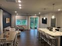 Open concept living space with hardwood floors, dining area, and modern kitchen with island seating at 159 Wood Orchid Ln, Garner, NC 27529