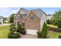 Charming brick home featuring a well-manicured lawn and inviting front entrance with blue door and shutters at 19 Arch Oak Ct, Clayton, NC 27527