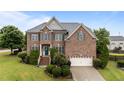 Charming brick home featuring a well-manicured lawn and inviting front entrance with blue door and shutters at 19 Arch Oak Ct, Clayton, NC 27527