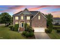Charming brick home with green shutters, a two-car garage, manicured lawn, and a welcoming entrance at 19 Arch Oak Ct, Clayton, NC 27527