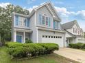 Charming two-story home with gray siding, white trim, blue shutters, and a two-car garage at 1928 Shadow Glen Dr, Raleigh, NC 27604