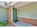 Inviting front entrance with a green door, brick accents, and well-maintained siding at 2 Donnelly Ct, Durham, NC 27713