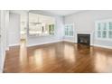Bright living room with hardwood floors, a fireplace, and an open view to the kitchen at 203 S South Bend Dr, Durham, NC 27713