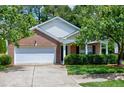 Cozy single-Gathering home with brick accents, vinyl siding, a two-car garage, and neat front yard at 204 Southern Style Dr, Holly Springs, NC 27540