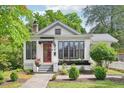 Front exterior of home with brick foundation, red door, black trim and lush landscaping at 2209 The Circle, Raleigh, NC 27608