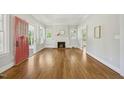 Bright living room featuring hardwood floors, a brick fireplace and a red door to the front yard at 2209 The Circle, Raleigh, NC 27608