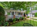 Inviting front porch with a swing, ceiling fans, white railings, and landscaped garden beds at 2309 Filigree Ct, Raleigh, NC 27614