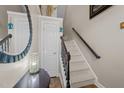 Inviting staircase with carpeted steps, wood railing, and decorative mirror at 2921 Imperial Oaks Dr, Raleigh, NC 27614