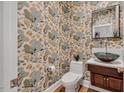 Charming powder room with unique floral wallpaper, vessel sink, and wood vanity at 3 Yancey, Pittsboro, NC 27312