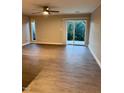 Spacious living room features new floors, a ceiling fan, and glass sliding doors leading to the outside at 3047 Huntleigh Dr, Raleigh, NC 27604