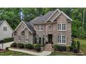 Charming brick home featuring classic architecture, lush greenery and inviting curb appeal at 3323 Cheswick Dr, Raleigh, NC 27609
