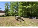Backyard with a wooden picnic table in a wooded area at 3504 Lexham Ct, Apex, NC 27539
