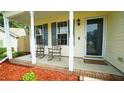 Inviting covered front porch with charming rocking chairs, decorative red mulch, and plenty of natural light at 3709 Fan Palm Ct, Raleigh, NC 27616