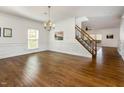 Spacious dining room with hardwood floors, wainscoting, and a chandelier at 405 Challenge Rd, Raleigh, NC 27603