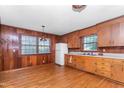 Traditional kitchen featuring wood paneling, white appliances, and ample counter space at 411 W Killiegrey St, Lillington, NC 27546