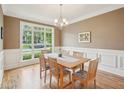 Traditional dining room with a large window, hardwood floors, and stylish chairs at 4125 Enfield Ridge Dr, Cary, NC 27519