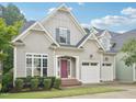Charming gray home featuring manicured landscaping and a welcoming red front door at 4125 Enfield Ridge Dr, Cary, NC 27519