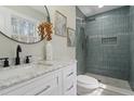 Modern bathroom features a walk-in shower with blue tile, marble counters, and updated fixtures at 4307 Pope Rd, Durham, NC 27707