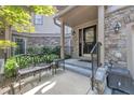 Cozy front porch featuring an iron bench, stylish black door with glass panels and stone accents at 4802 Glenmist Ct, Raleigh, NC 27612