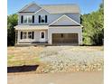 New two-story home featuring light gray siding, black shutters, and an attached two-car garage at 50 Moonraker Dr, Spring Hope, NC 27882