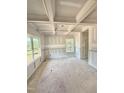 Unfinished living room boasts coffered ceilings, wainscoting, and bright natural light from the windows at 50 Moonraker Dr, Spring Hope, NC 27882