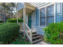 Inviting townhome entrance with stairs leading to the front door and blooming flowers at 6513 Hearthstone Dr, Raleigh, NC 27615