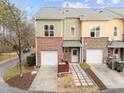 Rear view of a well-maintained townhouse featuring attached garages and tidy landscaping at 763 Blossom Grove Dr, Cary, NC 27519