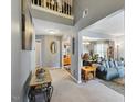 Open-concept living area with gray walls, neutral carpet, high ceilings, and staircase at 8008 Bright Oak Trl, Raleigh, NC 27616