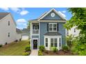 Charming blue two-story home featuring a bay window, landscaped front yard, and classic architectural details at 8925 Lee Brown Ridge Dr, Wake Forest, NC 27587