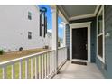 Inviting covered porch with white railings leads to a dark front door with welcome mat at 8925 Lee Brown Ridge Dr, Wake Forest, NC 27587