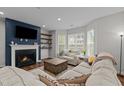 Cozy living room with fireplace, mounted TV, hardwood floors, and comfortable sectional sofa at 8925 Lee Brown Ridge Dr, Wake Forest, NC 27587
