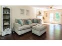Comfortable living room with hardwood floors, a plush sofa, and natural light from the french doors at 924 Magnolia Ridge Way, Fuquay Varina, NC 27526