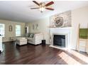 Inviting living room featuring hardwood floors, a fireplace, and a decorative stone wall at 924 Magnolia Ridge Way, Fuquay Varina, NC 27526