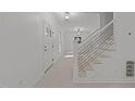 Foyer with stairs and modern metal handrail, neutral paint, and wood look floors at 10317 Roadstead W Way, Raleigh, NC 27613