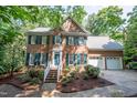 Attractive brick home features a two-car garage, gabled roof, blue shutters, and a well-manicured lawn at 104 Tutbury Pl, Cary, NC 27519