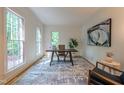 Bright home office with large windows, neutral decor, and a stylish rug and artwork at 104 Tutbury Pl, Cary, NC 27519