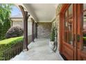 Spacious covered stone porch featuring stone columns, and double wood doors at 10540 Byrum Woods Dr, Raleigh, NC 27613