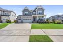 Charming two-story home with a well-maintained lawn, two car garage, and inviting front porch at 109 Obsidian Dr, Holly Springs, NC 27540
