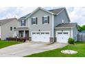 Two-story home with gray siding, black shutters, solar panels, well-manicured lawn, and a two car garage at 1104 Arden Trace Ct, Fuquay Varina, NC 27526