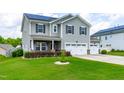 Two-story home with gray siding, black shutters, solar panels, well-manicured lawn, and a two car garage at 1104 Arden Trace Ct, Fuquay Varina, NC 27526