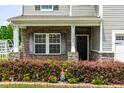 Close up of front porch with stone accents, lovely flowerbed, garden gnomes, and black front door at 1104 Arden Trace Ct, Fuquay Varina, NC 27526