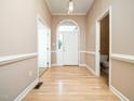 Home foyer with hardwood floors, white trim, and a view of the front door at 11221 Paddy Hollow Ln, Raleigh, NC 27614