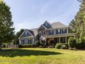 Elegant two-story home featuring stone accents, blue siding, lush landscaping, and a spacious front lawn at 1201 Kalworth Rd, Wake Forest, NC 27587