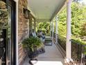 Cozy front porch with stone accents, decorative columns, iron railings, and comfortable seating for relaxing outdoors at 1201 Kalworth Rd, Wake Forest, NC 27587