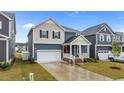 Attractive home with a welcoming front porch, manicured lawn, and a convenient attached garage at 125 Shadowdale Ln, Rolesville, NC 27571