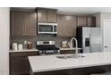 Contemporary kitchen boasts stainless appliances, gray cabinets, and quartz countertops at 1424 Rollman Farm Rd, Garner, NC 27603